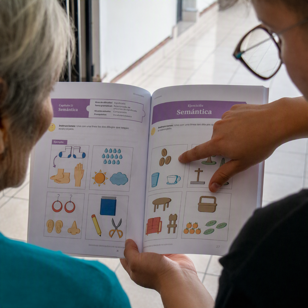 Cuidadora y adulta mayor trabajando juntas en un ejercicio del libro de memoria