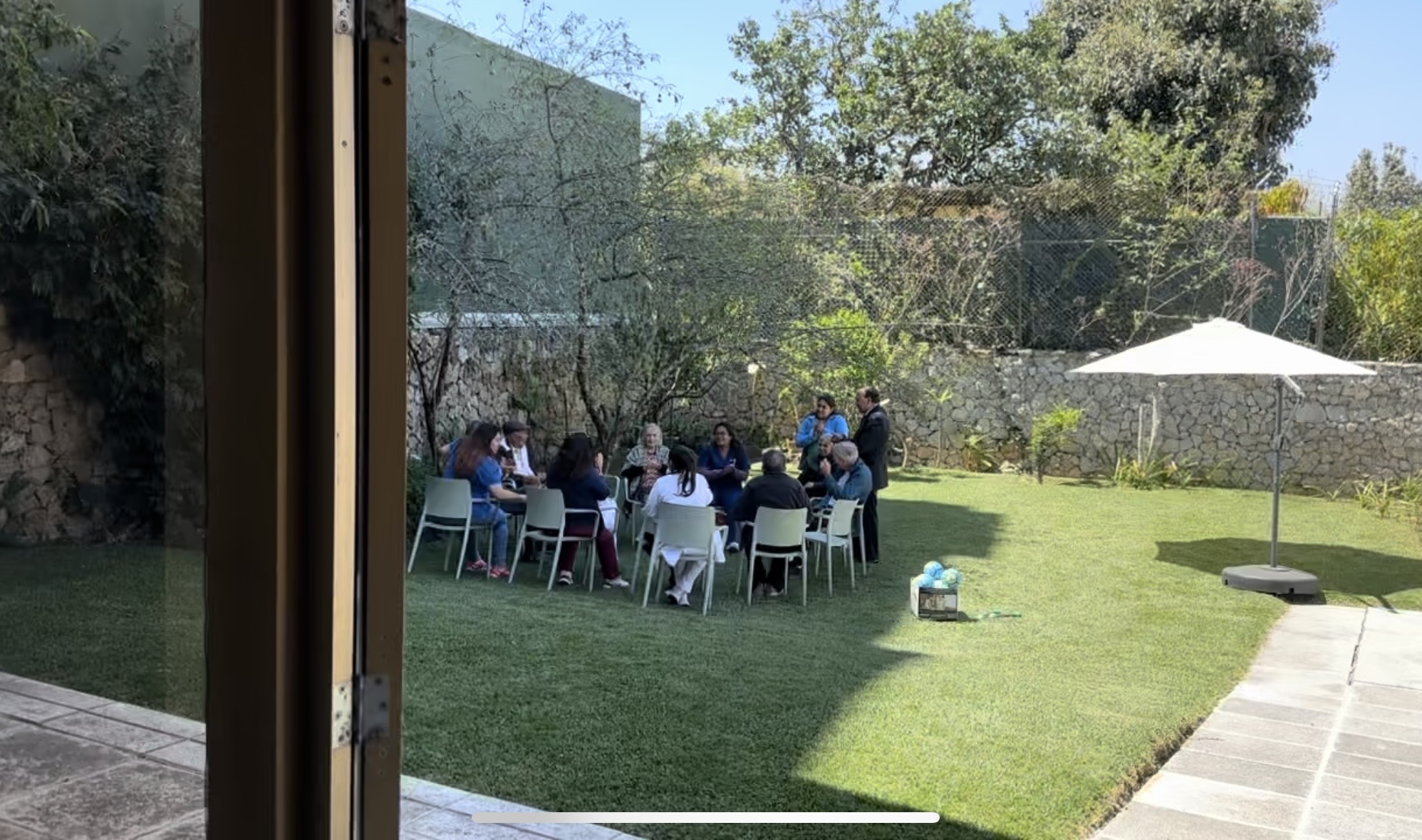 Adultos mayores y cuidadoras compartiendo actividades al aire libre en el jardín de la Residencia